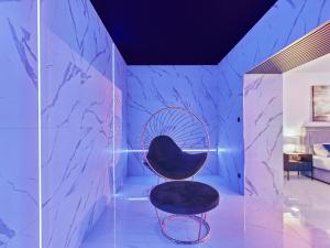 a black chair in a room with blue marble at Jacuzzi LoveAparts Marki Romantic Getaway in Marki +52 photos