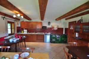 a kitchen with wooden cabinets and a table with chairs at Pferdehof Oberegg in Werfenweng
