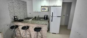 a kitchen with a white refrigerator and some stools at Porto Real Resort - Leisure and Fun in Mangaratiba