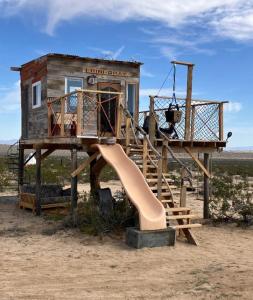 a play house with a slide and a playground at Treehouse in Joshua Tree