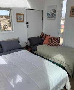 a bedroom with two beds and a couch at Treehouse in Joshua Tree