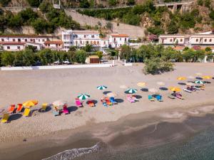 an aerial view of a beach with chairs and umbrellas at Testa di Monaco - Basic Beach Accommodations in Capo dʼOrlando