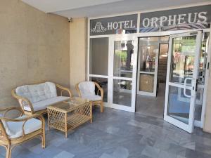 a hotel with chairs and a coffee table in front of a store at Хотел Орфей in Kŭrdzhali