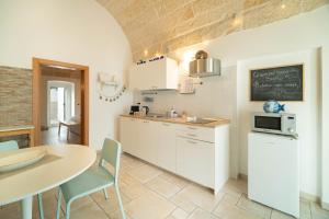 a kitchen with a table and a chalkboard on the wall at Le Contrade via Roma in Monopoli
