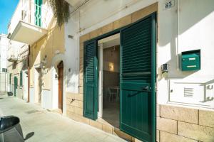 a green door on the side of a building at Le Contrade via Roma in Monopoli