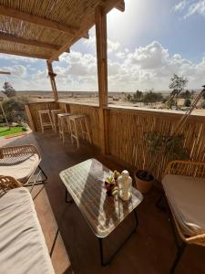 a patio with a table and chairs on a porch at הzimער של ביטון in Merhav Am