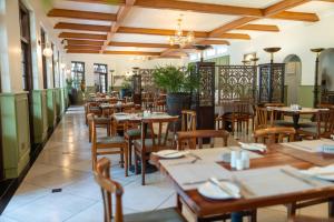 a restaurant with wooden tables and chairs in a room at Bronte Hotel in Harare