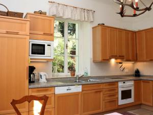 a kitchen with wooden cabinets and a sink and a window at Rosenvilla - Musikerschlössl in Bad Ischl