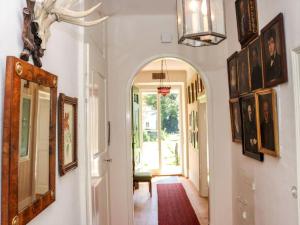 a hallway with paintings on the walls and an archway in a house at Rosenvilla - Musikerschlössl in Bad Ischl +7 photos