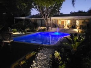 a swimming pool in front of a house at night at De Wingerd Wijnland Lodge in Paarl