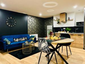 a living room with a blue couch and a table at Saphir in Plouray