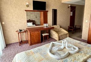 a hotel room with a bed and a desk with a television at Hotel Caesar Palace in Sunny Beach