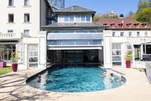 a group of people in a swimming pool in a building at Grand Hôtel & Spa Uriage in Uriage-les-Bains +19 photos
