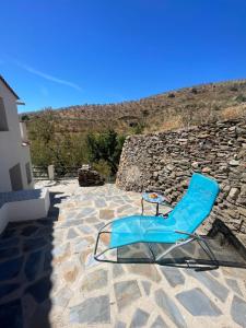 a blue chair sitting on a stone patio at Casa Amigos Sorvilan - la Bodega in Sorvilán