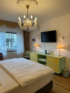 a bedroom with a large bed and a chandelier at Golden Rooms Exklusiv in Völkermarkt
