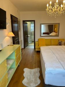 a bedroom with a large bed and a chandelier at Golden Rooms Exklusiv in Völkermarkt