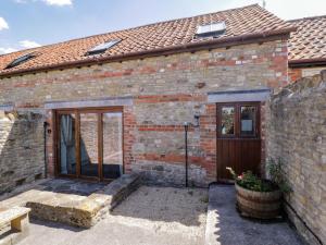 an old brick house with a wooden door at Barn Cottage with pre booked use of Indoor Swimming Pool in Frome