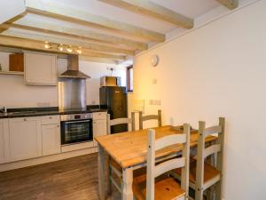a kitchen with a wooden table and a dining room at Barn Cottage with pre booked use of Indoor Swimming Pool in Frome