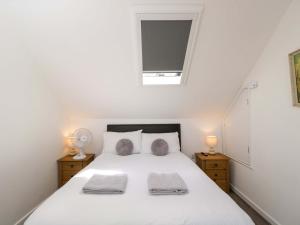 a bedroom with a white bed and a window at Barn Cottage with pre booked use of Indoor Swimming Pool in Frome +18 photos