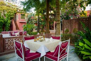 a white table with purple chairs in a garden at Ranbanka Palace in Jodhpur