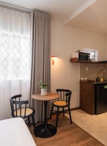 a room with a table and chairs and a kitchen at Saigon Maison 1988 BUI VIEN Centre in Ho Chi Minh City