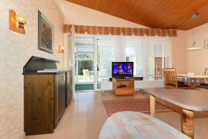 a living room with a television and a table at Ferienhaus Blauer Anker in Bensersiel