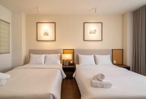 two beds in a hotel room with towels at Saigon Maison 1988 BUI VIEN Centre in Ho Chi Minh City