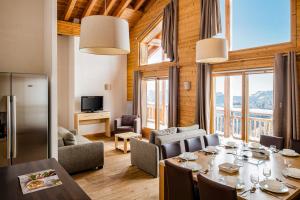 a dining room with a table and chairs and a living room at Dormio Resort Les Portes du Grand Massif in Flaine