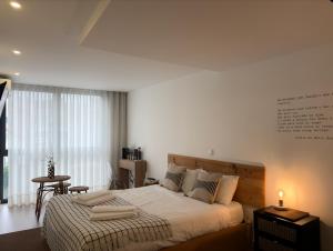 a bedroom with a large bed and a table at Autor Guesthouse in Vila do Conde