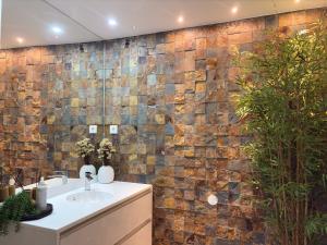 a bathroom with a sink and a brick wall at Autor Guesthouse in Vila do Conde +26 photos