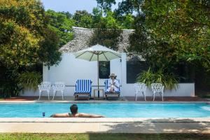 a man laying in a swimming pool next to a woman at Marari Beach Resort Alleppey - A CGH Earth Experience in Alleppey