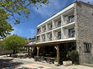 a building with tables and chairs in front of it at Hotel Restaurant Sole E Monti in Quenza