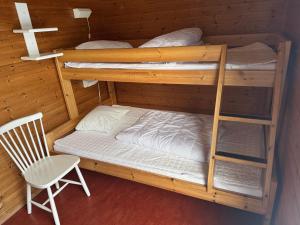 a room with two bunk beds and a chair at Skutstuga 2 - Gruvbacken Huså in Järpen