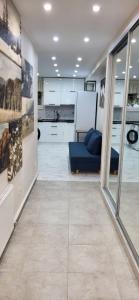 a living room with a blue couch and a kitchen at B apartment Рахів in Rakhiv
