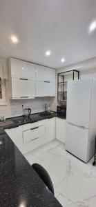a kitchen with white cabinets and a white refrigerator at B apartment Рахів in Rakhiv