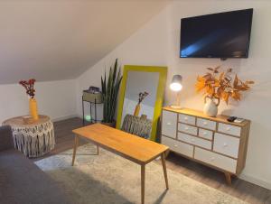 a living room with a dresser and a tv on the wall at Autor Guesthouse in Vila do Conde