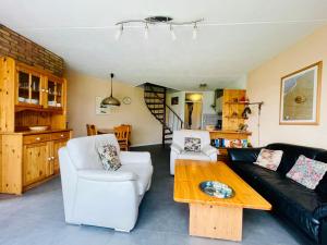 a living room with a couch and a table at Heggerank 80* in Nieuwvliet