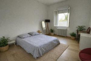 a bedroom with a bed and a window at Grande Chambre avec parking possible en supplément, BORDEAUX BASTIDE in Bordeaux
