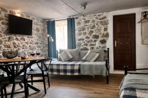 a living room with a bed and a table and a tv at Armonia Cosy Loft Chora Samothraki View in Samothraki