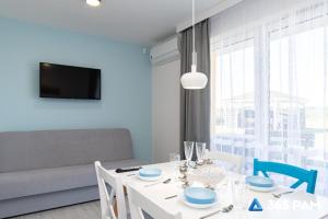 a dining room with a white table and blue chairs at 365PAM - Kolory Lata - KLIMATYZACJA, PLAC ZABAW, GRILL in Sarbinowo