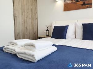 a bedroom with two beds with white towels on the floor at 365PAM - Kolory Lata - KLIMATYZACJA, PLAC ZABAW, GRILL in Sarbinowo