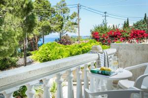 a white balcony with a table and chairs and flowers at Sunset Beach Appartments in Minia