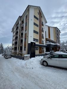 a car parked in the snow in front of a building at MM Sofy in Palisat