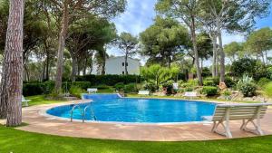 a swimming pool in a yard with benches and trees at Puig Sa Guilla 1C B2 in Pals