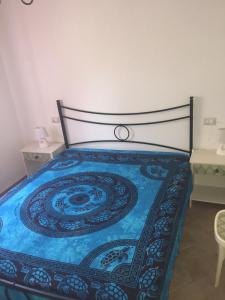 sypialnia z łóżkiem z niebieską narzutą w obiekcie Villa Bonu w mieście Torre delle Stelle