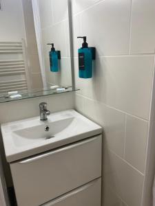 a white bathroom with a sink and a mirror at Gite de Sainte Gemme in Sainte-Gemme