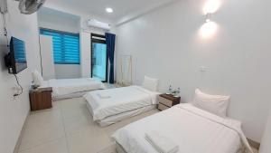 a bedroom with two beds and a television in it at HT Airport Inn in Phù Xá Ðoài +54 photos