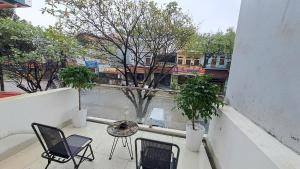 a balcony with chairs and a table and a view of a street at HT Airport Inn in Phù Xá Ðoài