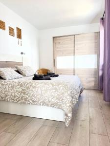 a bedroom with a bed and a large window at First Love in Caleta De Fuste