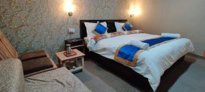 a bedroom with a large bed and a couch at Hill Side Cabin, Pangong in Spangmik